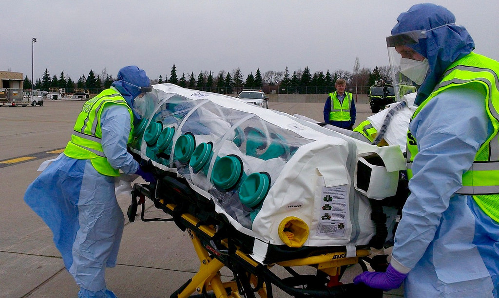 A mock patient is being transported from the aircraft to an ambulance destined for the Regional Ebola and Other Special Pathogen Treatment Center at the University of Minnesota Medical Center as part of the Tranquil Shift exercise.  