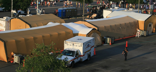 An ambulance backs up to a series of medical tents