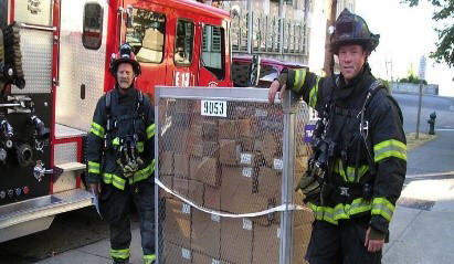 Two firefighters standing next to a CHEMPACK shipment
